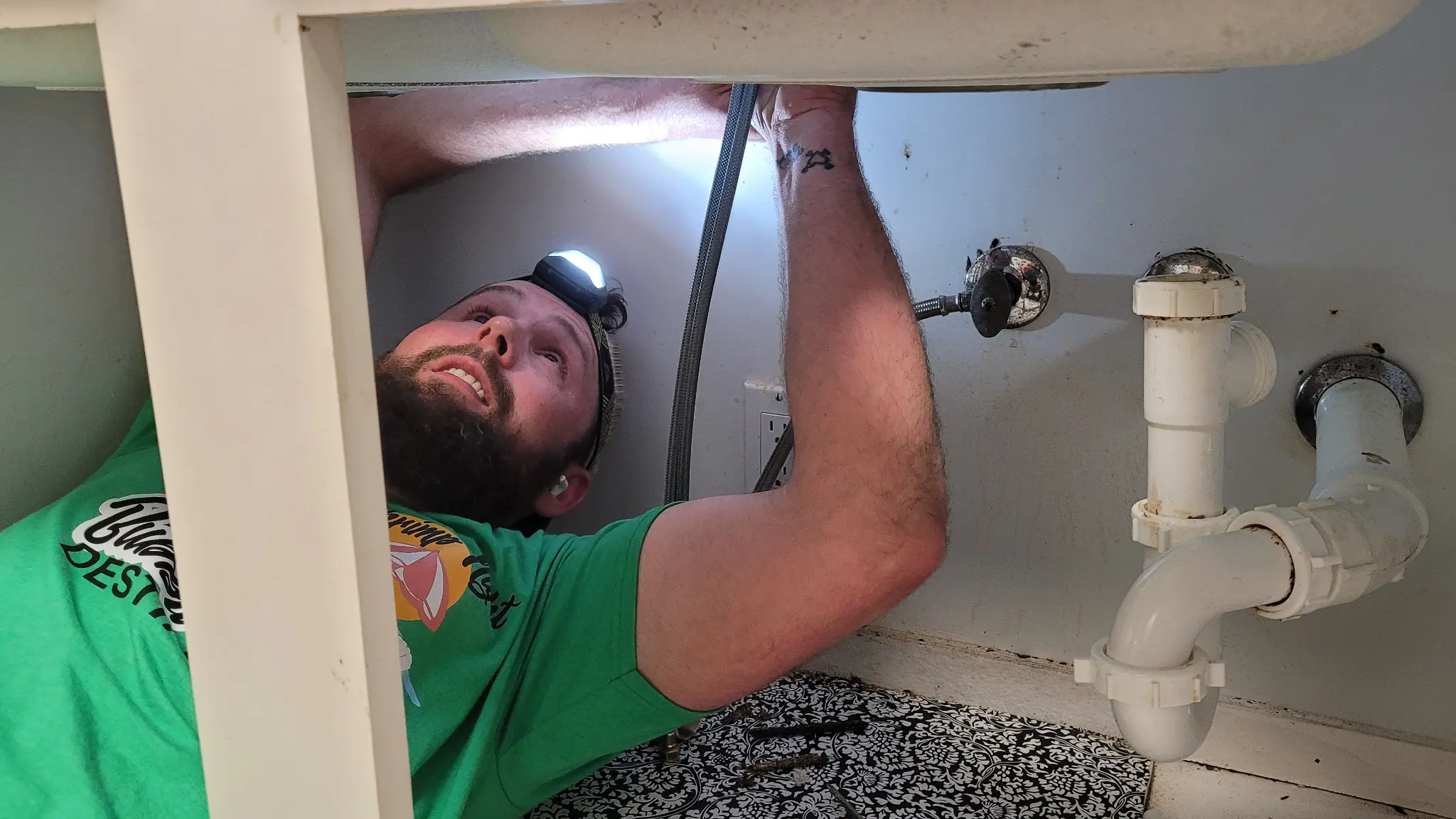 Millennial repairman installing under sink
