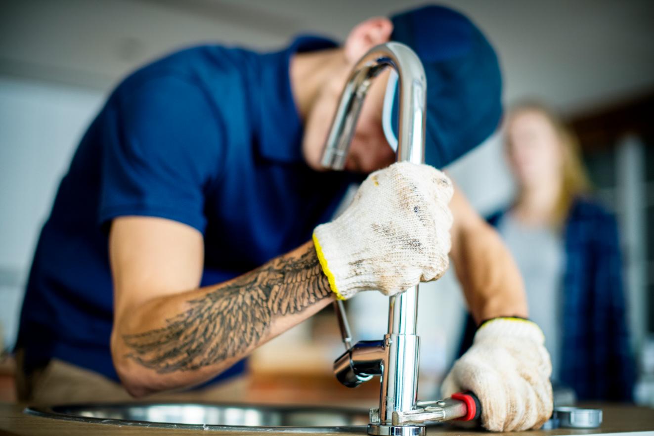 Professional plumber fixing kitchen sink