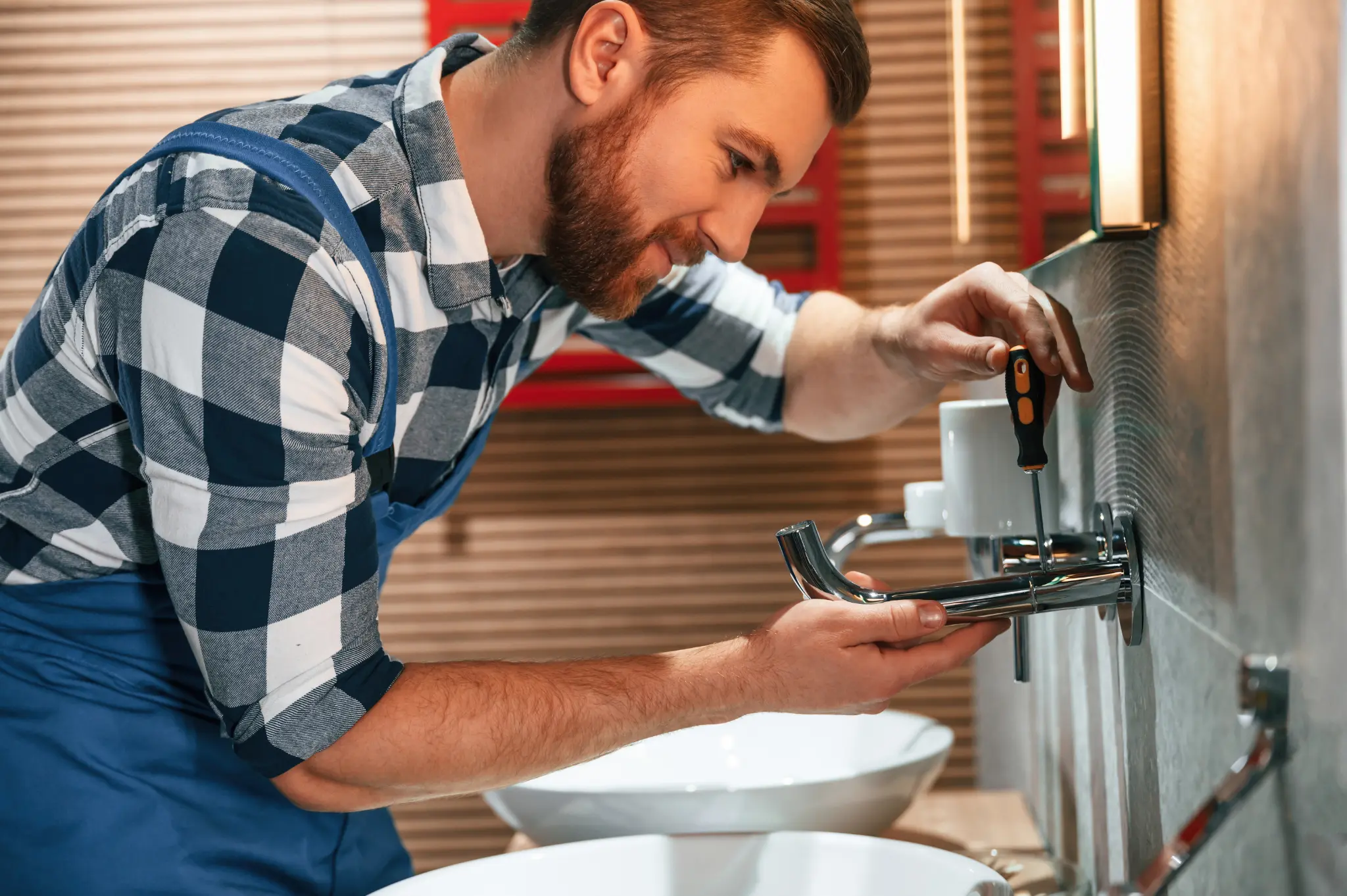 Plumber using screwdriver for repairs